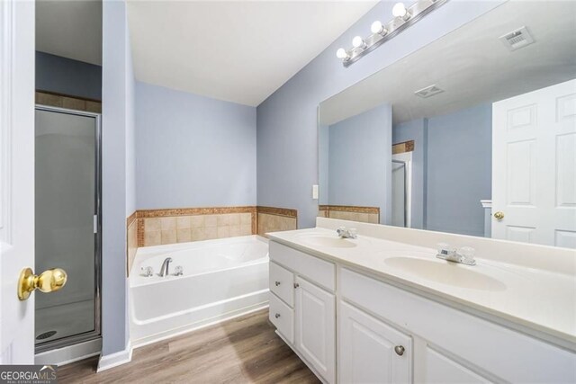 bathroom with a garden tub, a sink, a stall shower, and visible vents