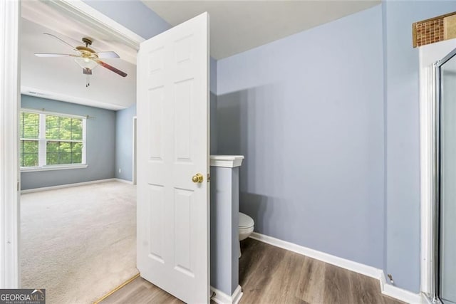 bathroom featuring baseboards, a ceiling fan, toilet, and wood finished floors