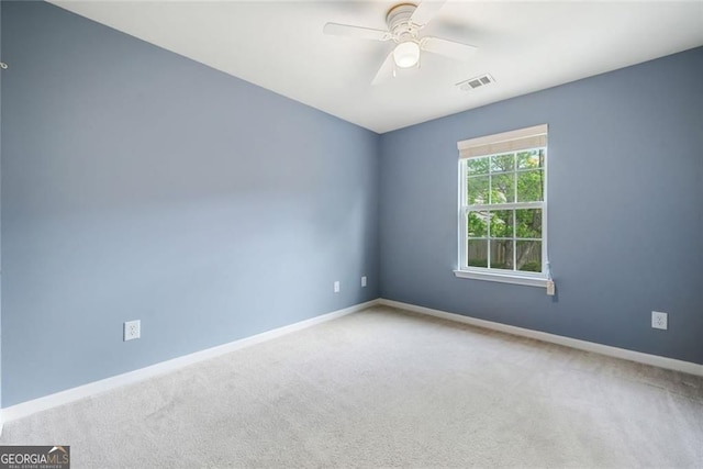 carpeted empty room featuring visible vents, baseboards, and ceiling fan