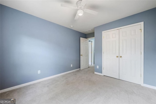 unfurnished bedroom featuring baseboards, a ceiling fan, carpet, and a closet