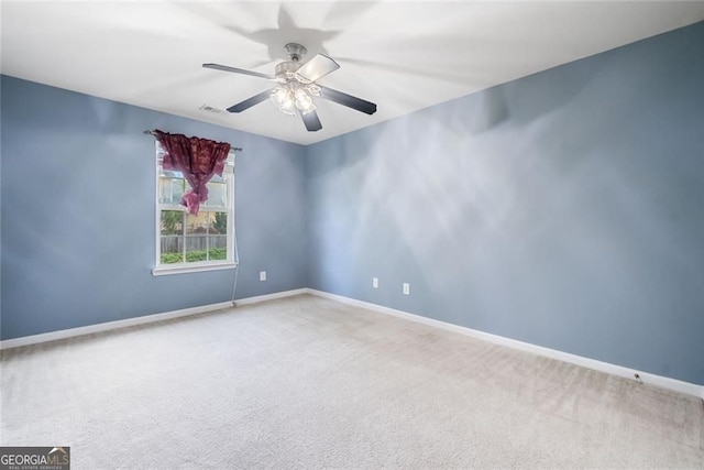 carpeted empty room featuring baseboards, ceiling fan, and visible vents