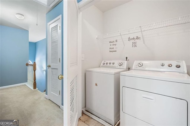 laundry area with laundry area, light colored carpet, attic access, baseboards, and washer and clothes dryer