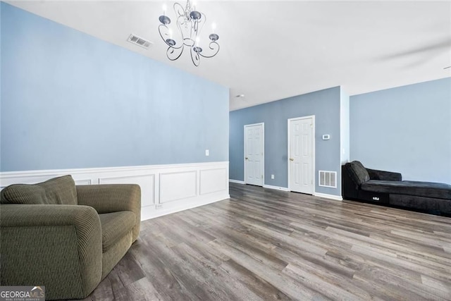 living area with a notable chandelier, wood finished floors, and visible vents