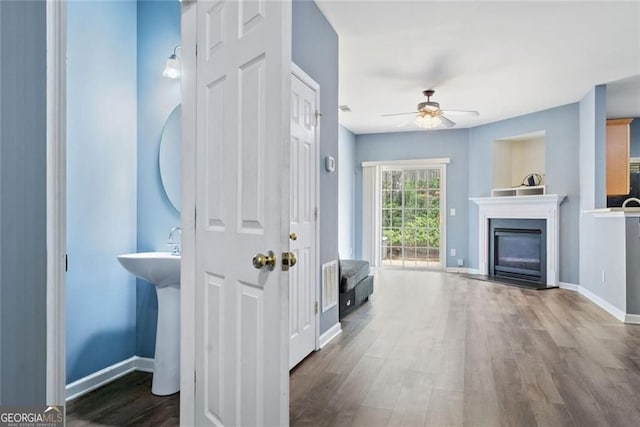 3366 Thornbridge Dr, Powder Springs, GA 30127 - interior space featuring a ceiling fan, baseboards, a glass covered fireplace, and wood finished floors