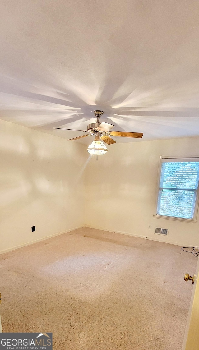 spare room featuring visible vents, carpet floors, and ceiling fan