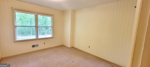 unfurnished room featuring visible vents, baseboards, and light carpet