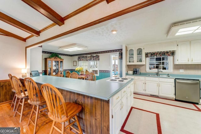 417 Pulliam Ln, Royston, GA 30662 - kitchen featuring white cabinets, stainless steel dishwasher, a sink, white electric cooktop, and a breakfast bar