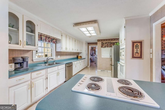 417 Pulliam Ln, Royston, GA 30662 - kitchen featuring white cabinets, stainless steel appliances, ornamental molding, a sink, and glass insert cabinets