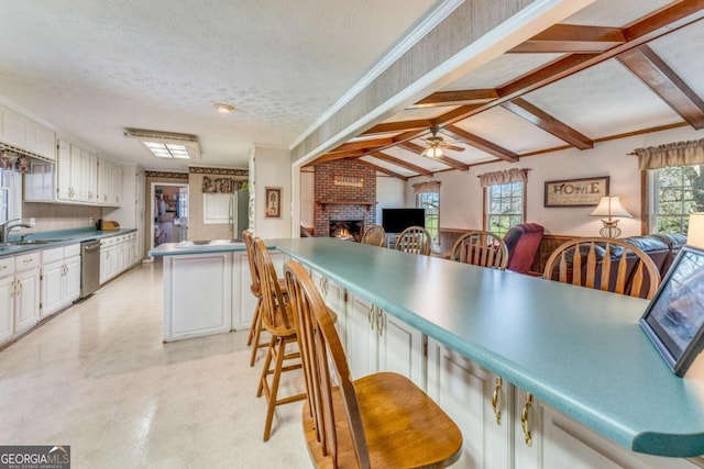 417 Pulliam Ln, Royston, GA 30662 - kitchen with a kitchen breakfast bar, a ceiling fan, light floors, dishwasher, and a fireplace