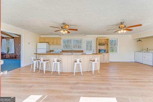 417 Pulliam Ln, Royston, GA 30662 - kitchen featuring washing machine and clothes dryer, a ceiling fan, white appliances, and light wood-type flooring