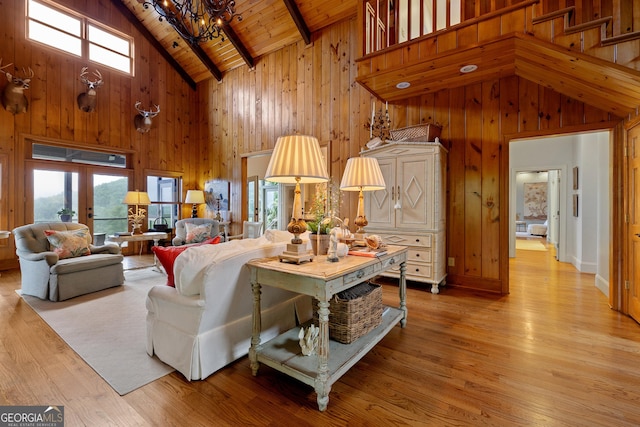 295 Goble Gap Rd, Clayton, GA 30525 - living area with high vaulted ceiling, wood walls, a chandelier, a wood ceiling with exposed beams, and light wood-style floors