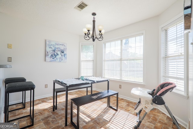 dining area with baseboards, an inviting chandelier, and plenty of natural light