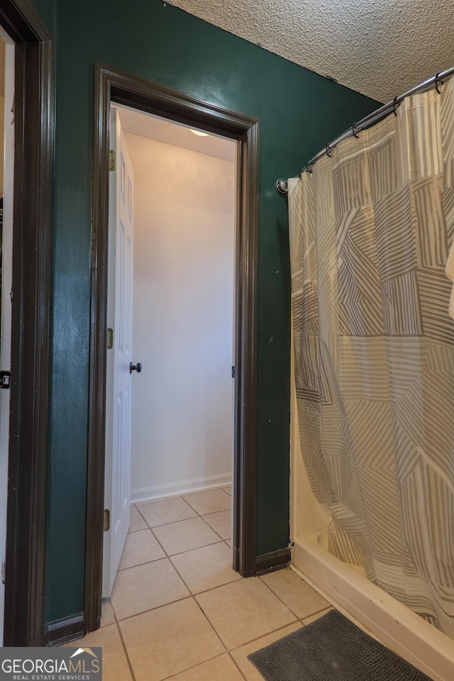 full bath featuring tile patterned flooring, a textured ceiling, and a shower with shower curtain