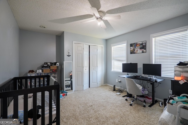 carpeted bedroom featuring baseboards, ceiling fan, a textured ceiling, and a closet