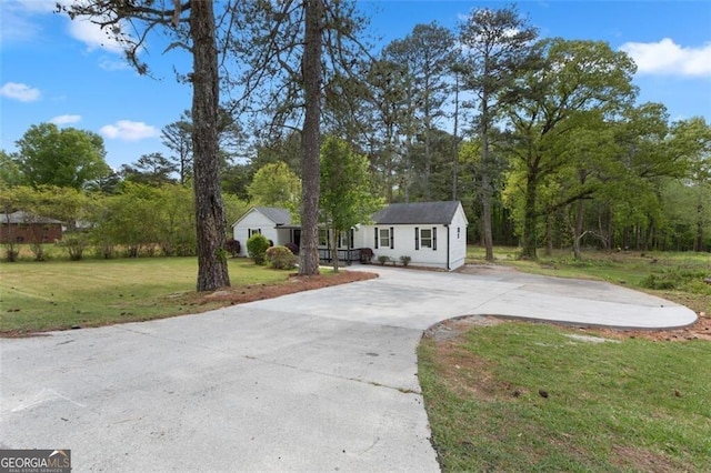 single story home with a front lawn, driveway, and an outbuilding