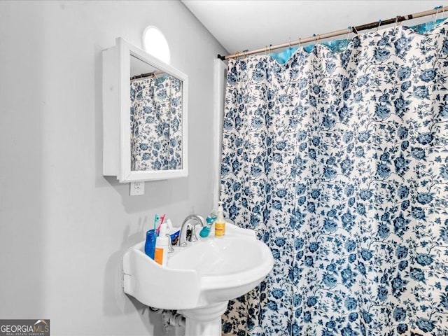 bathroom with curtained shower and a sink