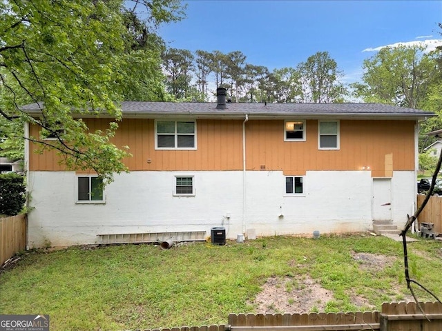view of side of home with cooling unit, a yard, and fence