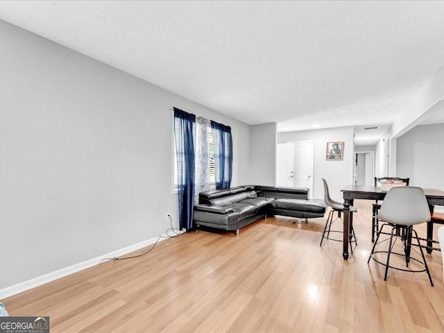 living area featuring baseboards and light wood-type flooring