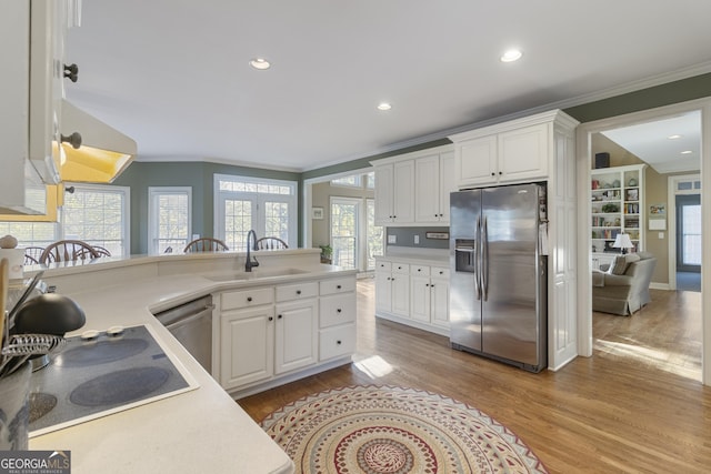 kitchen featuring a sink, white cabinetry, appliances with stainless steel finishes, and crown molding