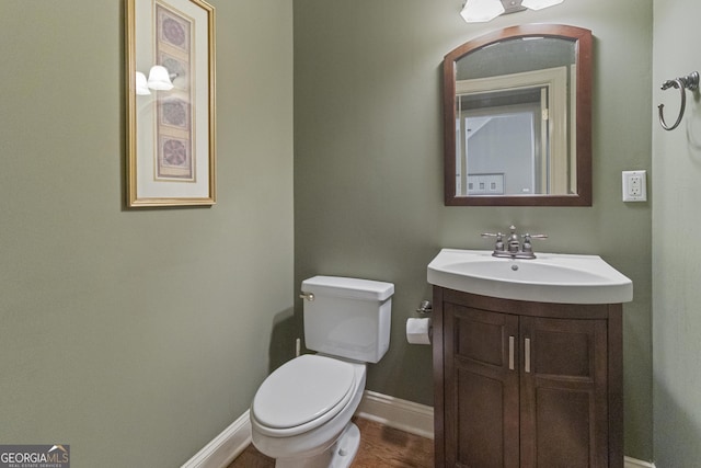 bathroom featuring vanity, toilet, and baseboards