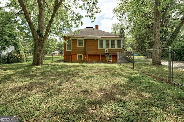 19 Mcdonough St, Hampton, GA 30228 - back of house featuring a lawn, fence, and a chimney