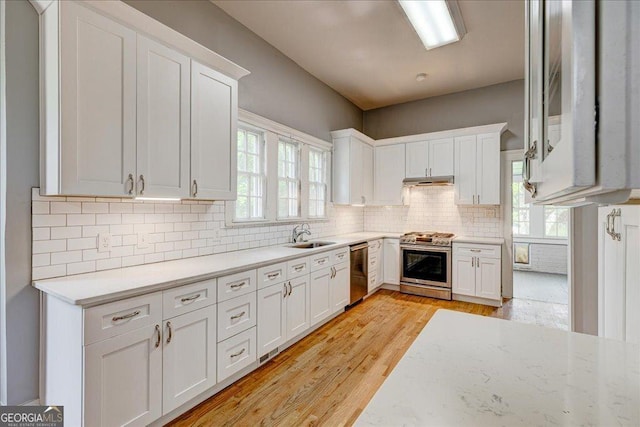 19 Mcdonough St, Hampton, GA 30228 - kitchen with white cabinetry, decorative backsplash, a sink, stainless steel appliances, and light wood-type flooring