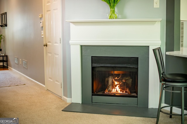 details with carpet flooring, baseboards, and a lit fireplace