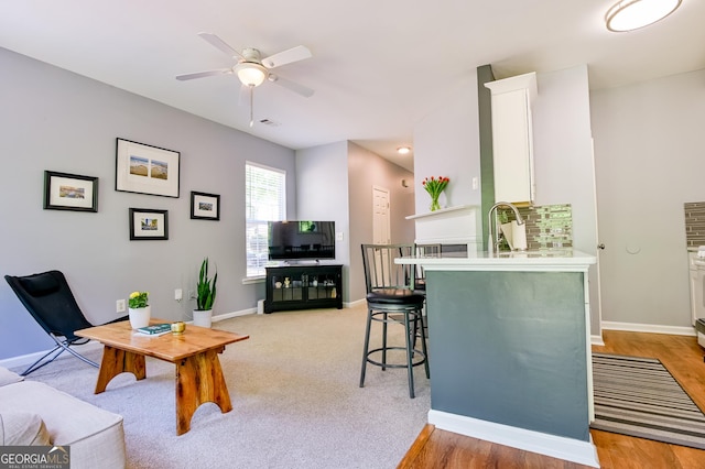 living room featuring baseboards and ceiling fan