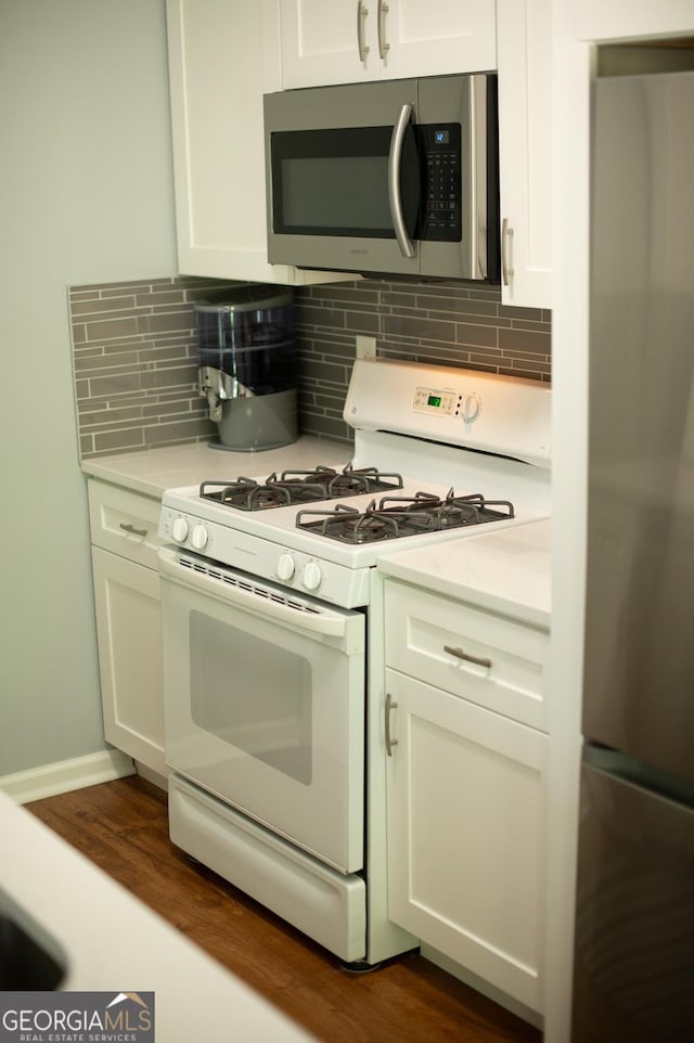 kitchen featuring light countertops, white cabinetry, dark wood-type flooring, and appliances with stainless steel finishes