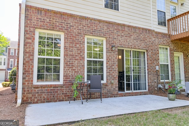 exterior space featuring brick siding and a patio area