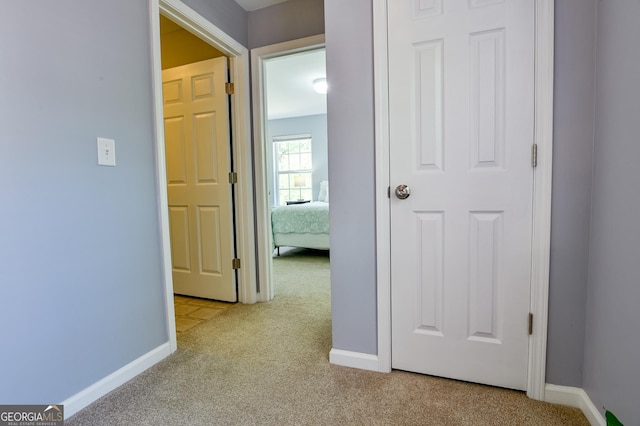 hallway with baseboards and carpet flooring