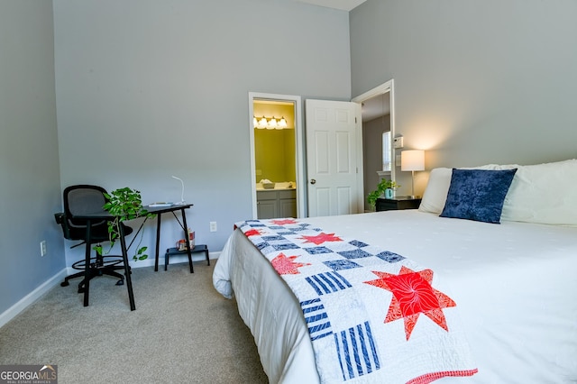 bedroom featuring connected bathroom, baseboards, a high ceiling, and carpet