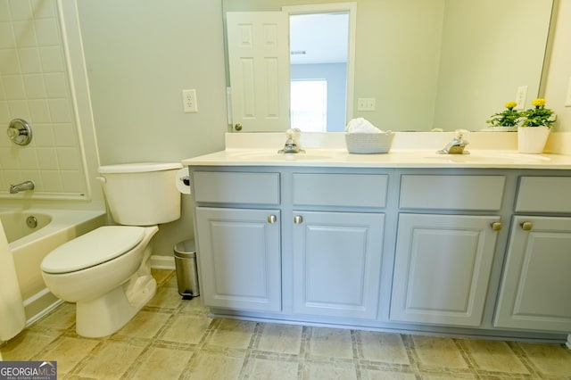 bathroom featuring double vanity, toilet, and a sink