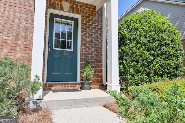 entrance to property with brick siding and covered porch