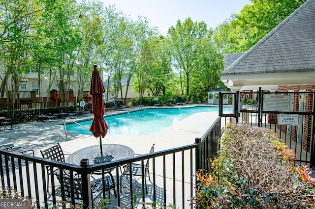community pool featuring a patio area and fence