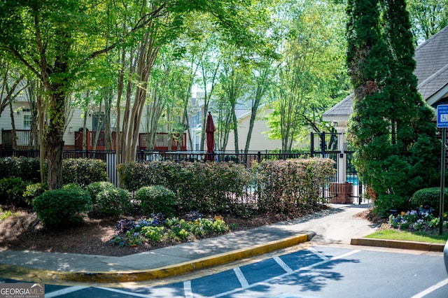 view of property's community with uncovered parking and fence