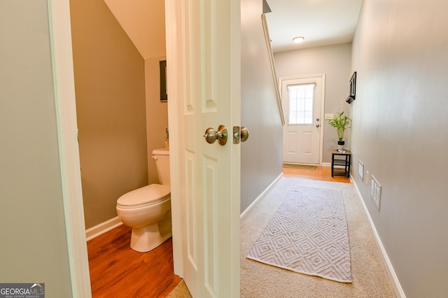 interior space featuring toilet and baseboards