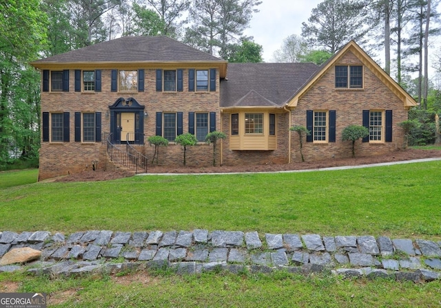 5621 Wildwood Trl, Lithonia, GA 30038 - colonial-style house featuring a shingled roof, a front lawn, and brick siding