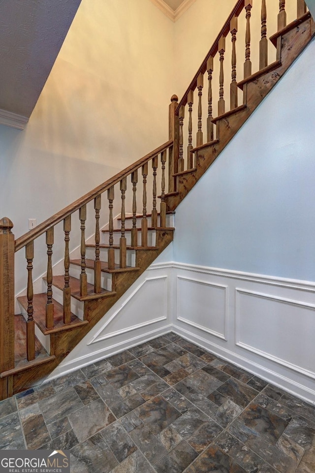 5621 Wildwood Trl, Lithonia, GA 30038 - staircase featuring stone finish floor, a decorative wall, crown molding, and wainscoting