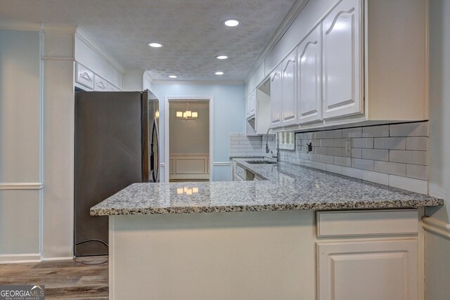 5621 Wildwood Trl, Lithonia, GA 30038 - kitchen with white cabinets, wood finished floors, backsplash, and stainless steel fridge with ice dispenser
