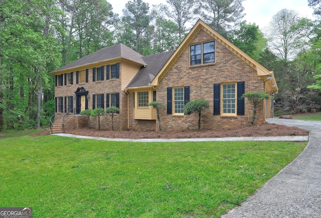 5621 Wildwood Trl, Lithonia, GA 30038 - colonial inspired home with brick siding, roof with shingles, and a front lawn