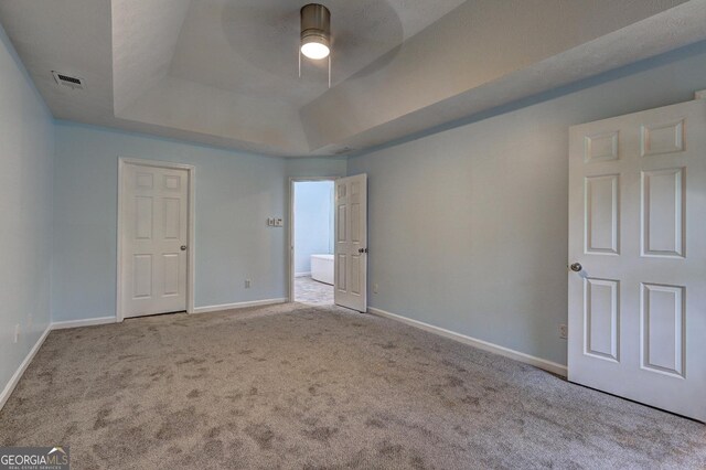 5621 Wildwood Trl, Lithonia, GA 30038 - unfurnished bedroom with baseboards, a tray ceiling, visible vents, and carpet