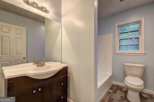 5621 Wildwood Trl, Lithonia, GA 30038 - bathroom featuring baseboards, stone finish flooring, vanity, and toilet