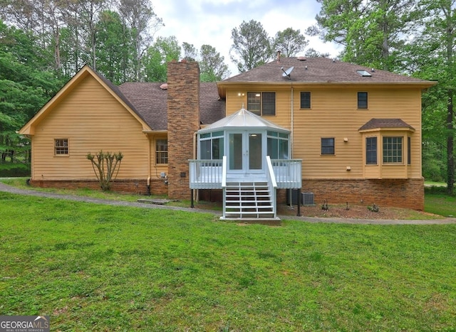 5621 Wildwood Trl, Lithonia, GA 30038 - rear view of house with stairway, a lawn, a chimney, and a sunroom