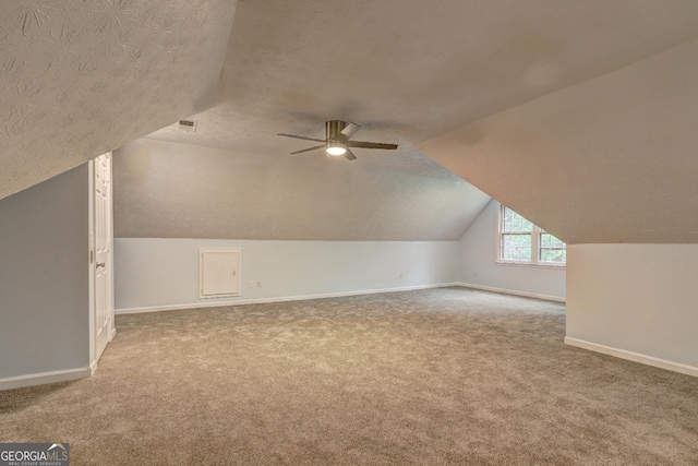 5621 Wildwood Trl, Lithonia, GA 30038 - bonus room featuring baseboards, lofted ceiling, a textured ceiling, and carpet floors