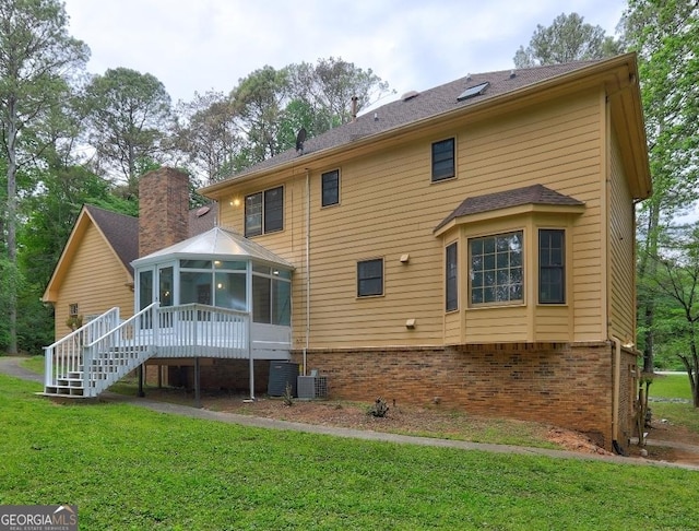 5621 Wildwood Trl, Lithonia, GA 30038 - back of house with a chimney, brick siding, a lawn, stairs, and a sunroom