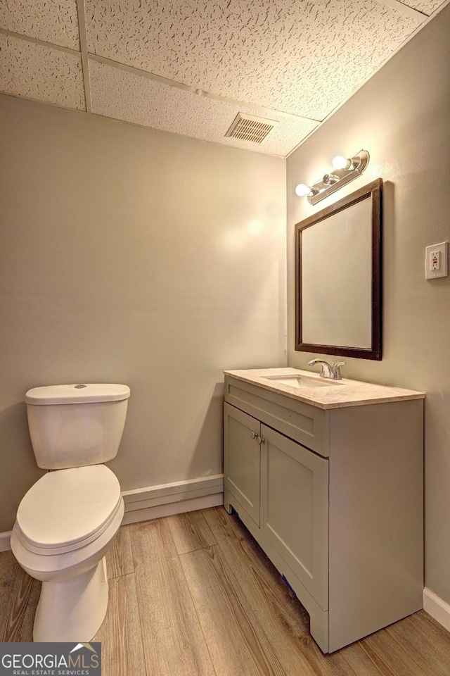 5621 Wildwood Trl, Lithonia, GA 30038 - bathroom featuring wood finished floors, vanity, a drop ceiling, baseboards, and visible vents
