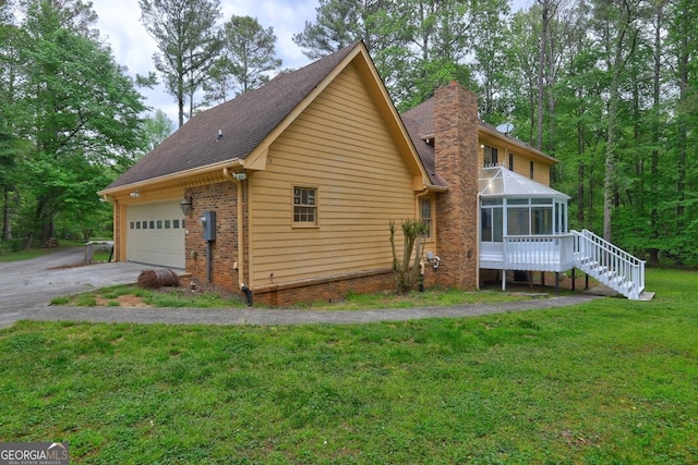 5621 Wildwood Trl, Lithonia, GA 30038 - view of home's exterior with a chimney, driveway, a yard, a sunroom, and roof with shingles