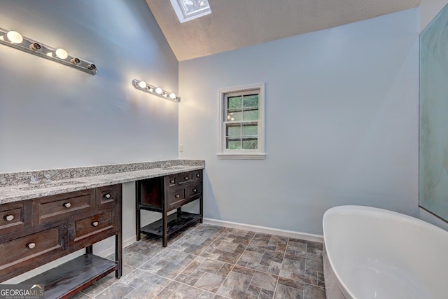 5621 Wildwood Trl, Lithonia, GA 30038 - full bath with stone finish floor, vanity, lofted ceiling with skylight, baseboards, and a soaking tub