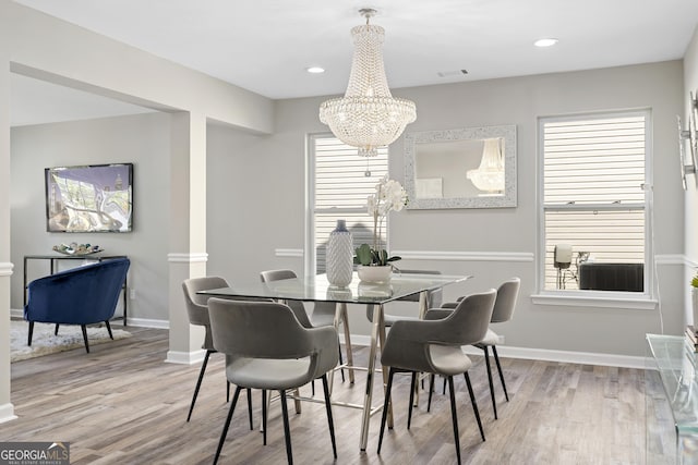 dining space with recessed lighting, wood finished floors, baseboards, visible vents, and a notable chandelier
